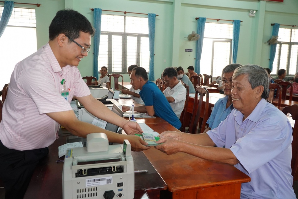 Cán bộ NHCSXH huyện Châu Thành giải ngân tại điểm giao dịch xã