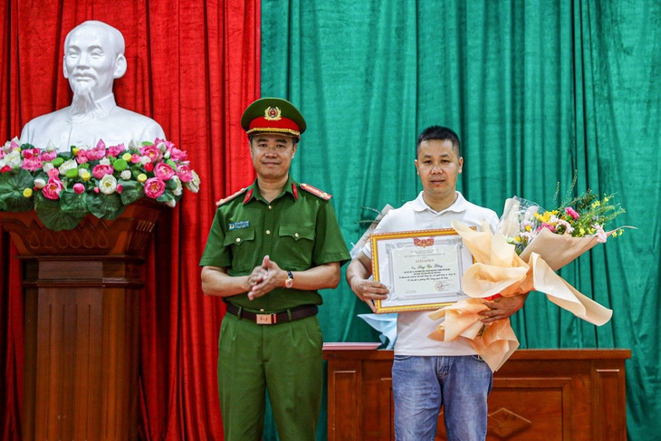 Đại tá Nguyễn Ngọc Quyền, trưởng Công an quận Hà Đông, trao giấy khen của UBND quận Hà Đông cho anh Lèng Văn Bằng - Ảnh: N.T.