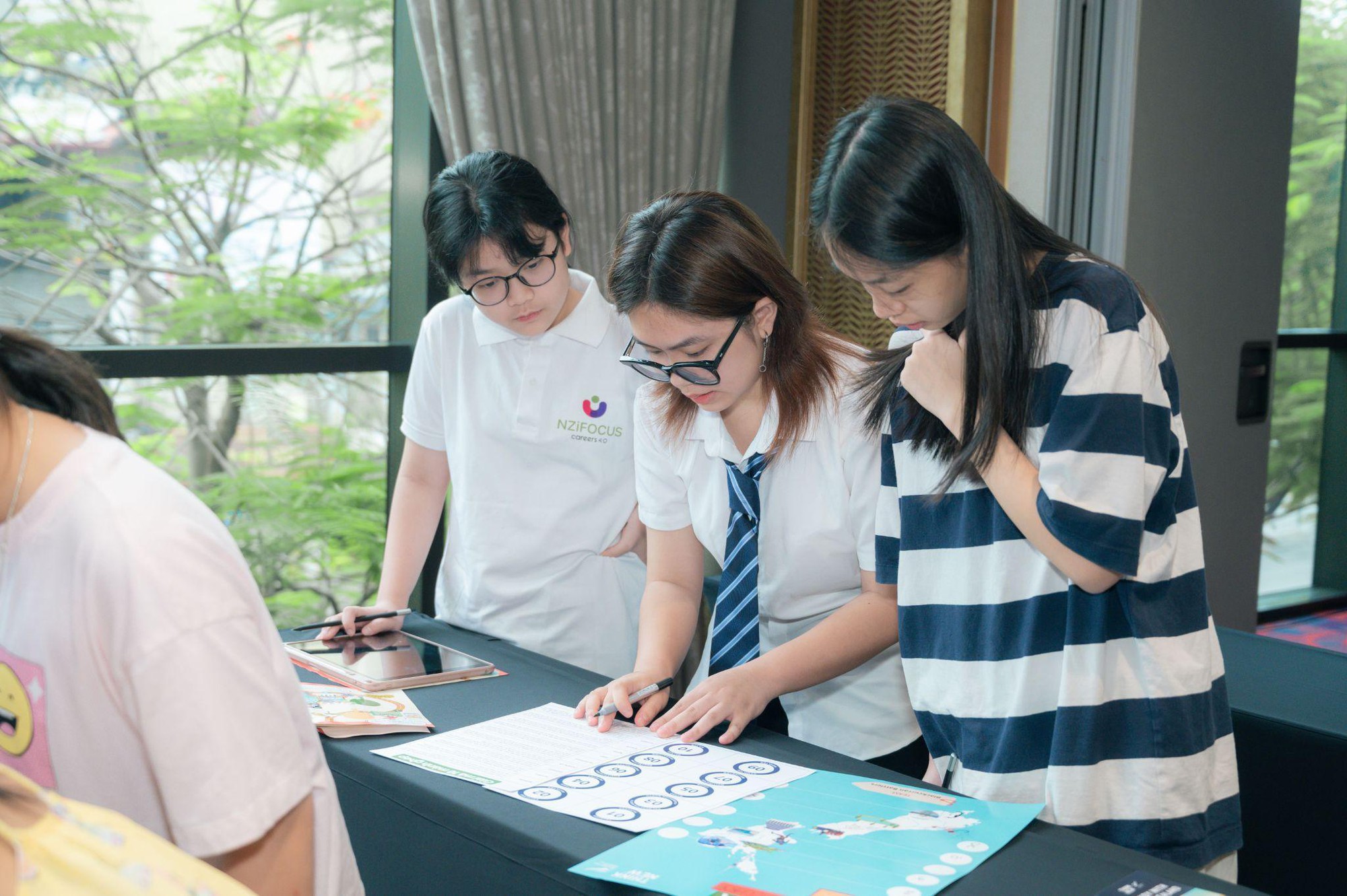 A group of people looking at a piece of paper  Description automatically generated