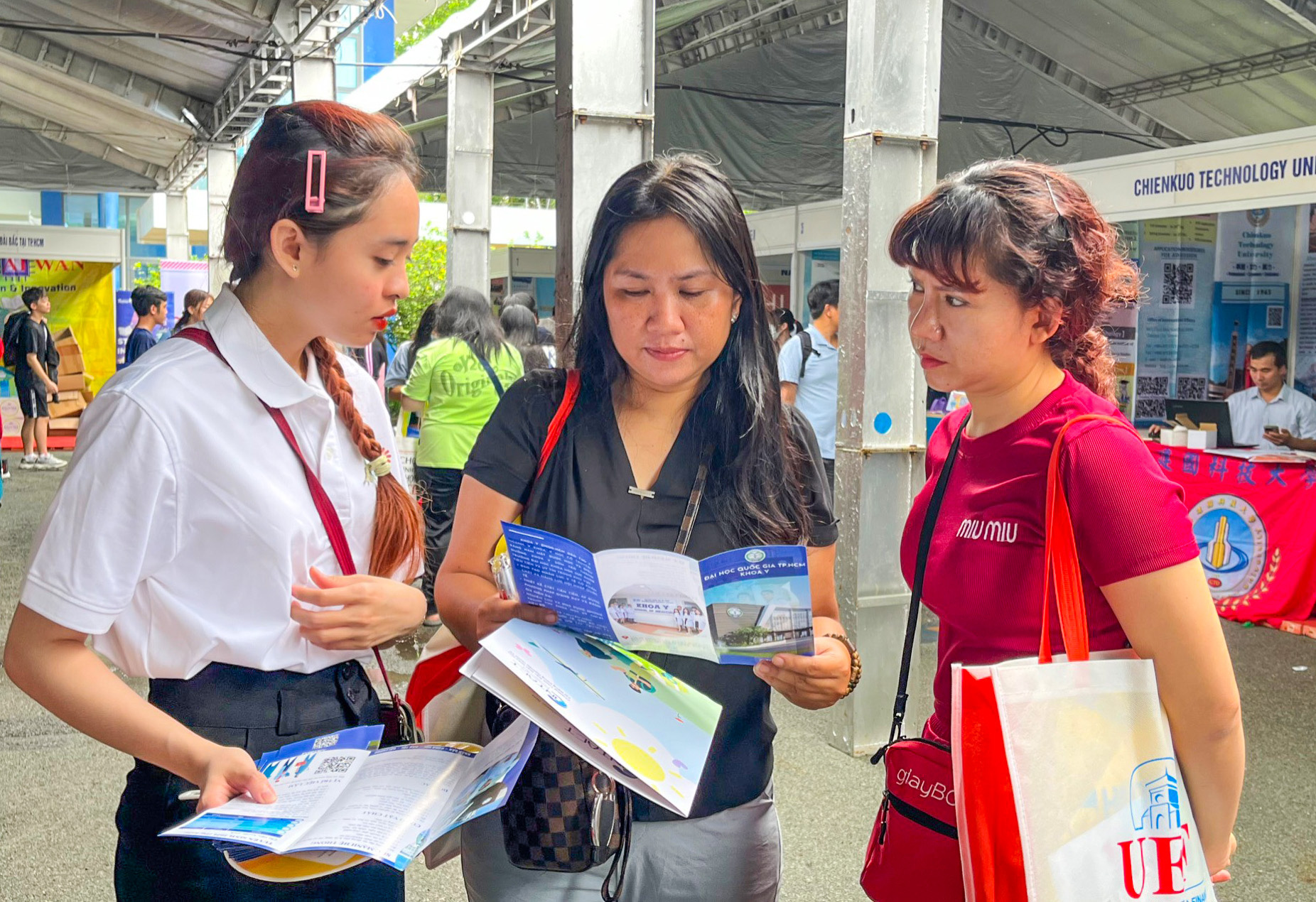 Cô Tuyến (giữa) và cô Thủy (bìa phải) được chị Lê Chung Hoa - bộ phận tuyển sinh Khoa Y tư vấn chi tiết về chỉ tiêu tuyển sinh và khối ngành xét tuyển - Ảnh: TRẦN KIM QUYÊN