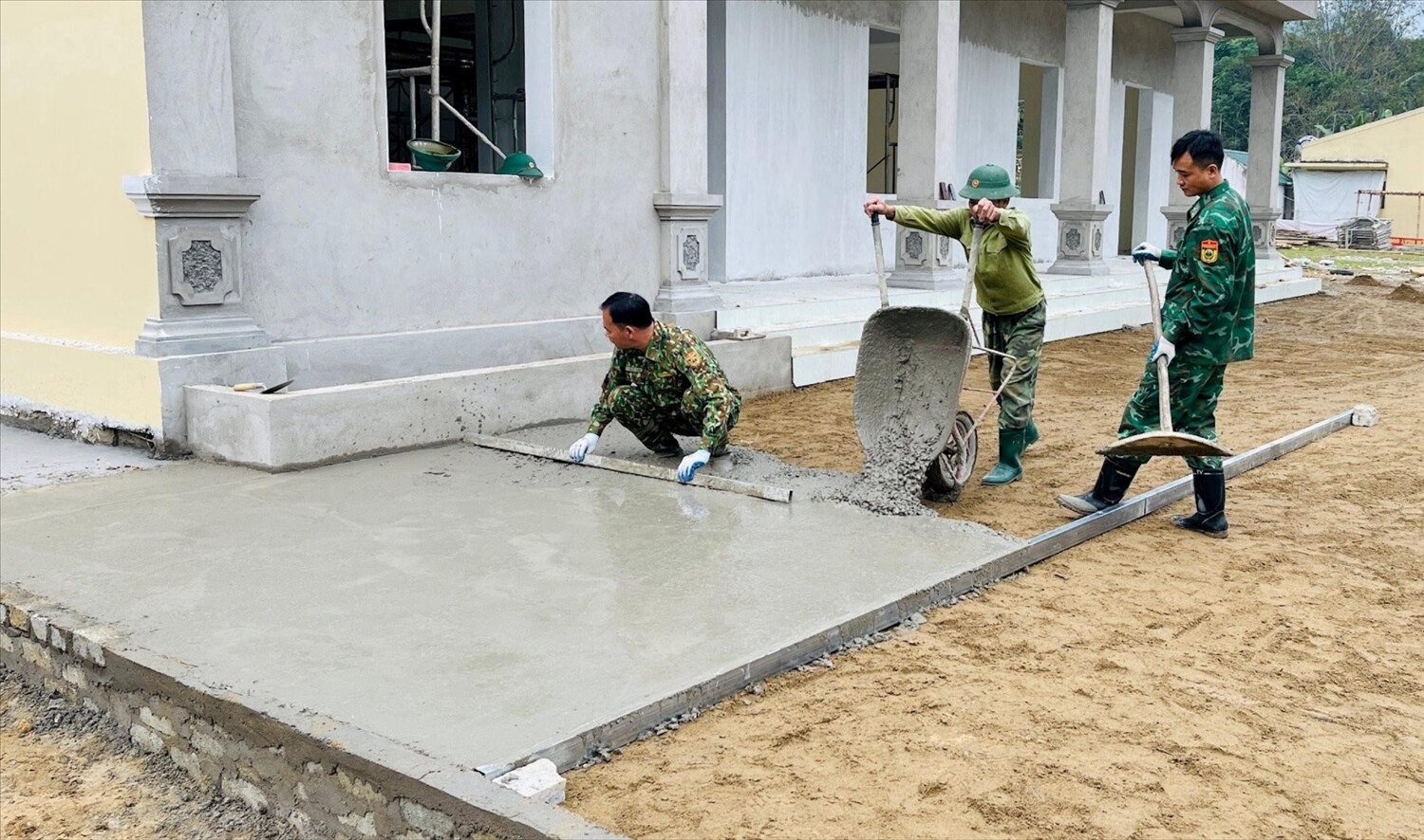 Tổ thợ xây Đồn Biên phòng Tam Quang hỗ trợ bản Tùng Hương đổ bê tông sân nhà văn hoá cộng đồng.