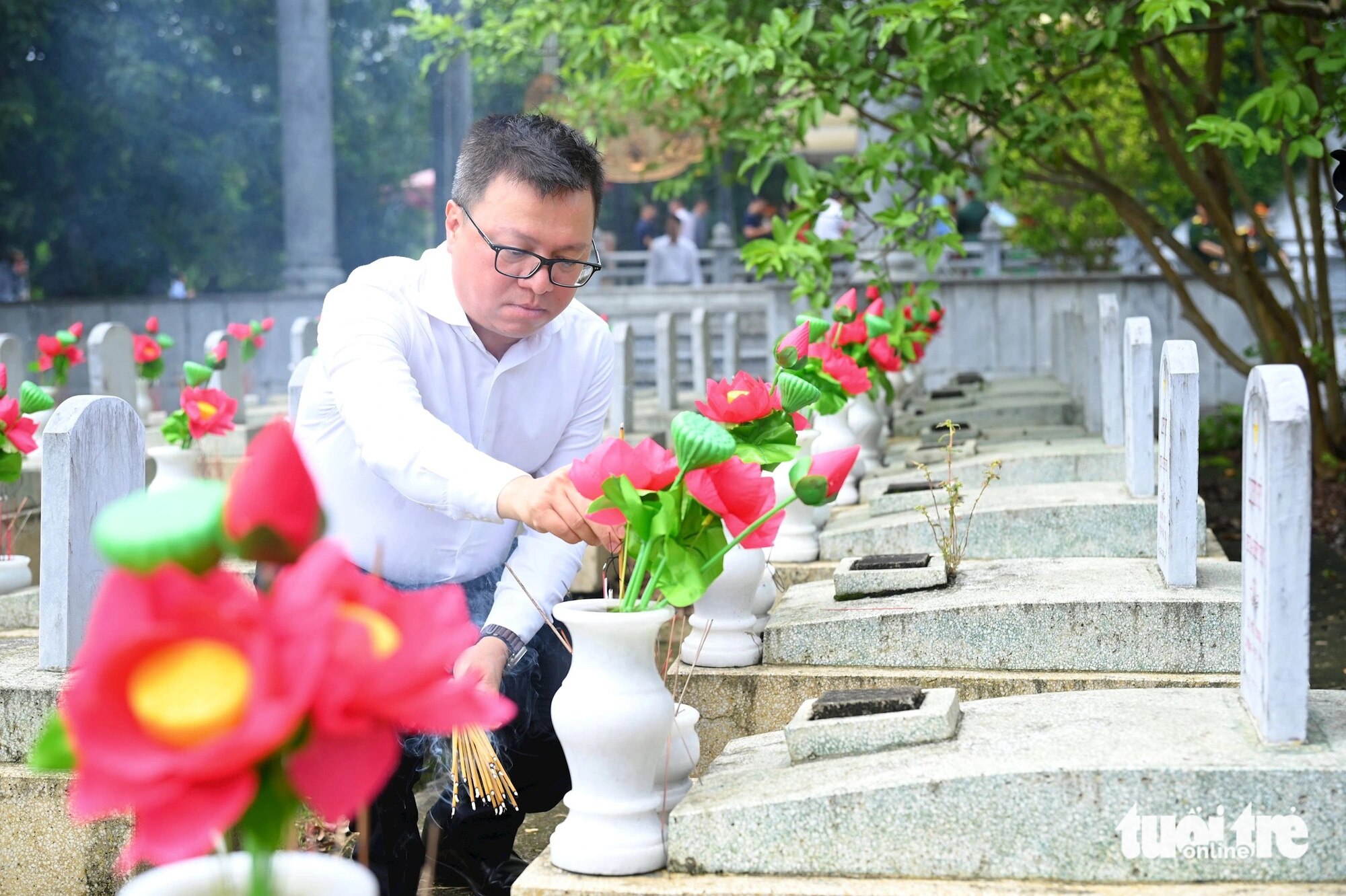 Ông Lê Quốc Minh - tổng biên tập báo Nhân Dân, phó trưởng Ban Tuyên giáo Trung ương, chủ tịch Hội Nhà báo Việt Nam - thắp hương phần mộ liệt sĩ tại nghĩa trang quốc tế Việt - Lào, huyện Anh Sơn, Nghệ An - Ảnh: CƯỜNG NGUYỄN