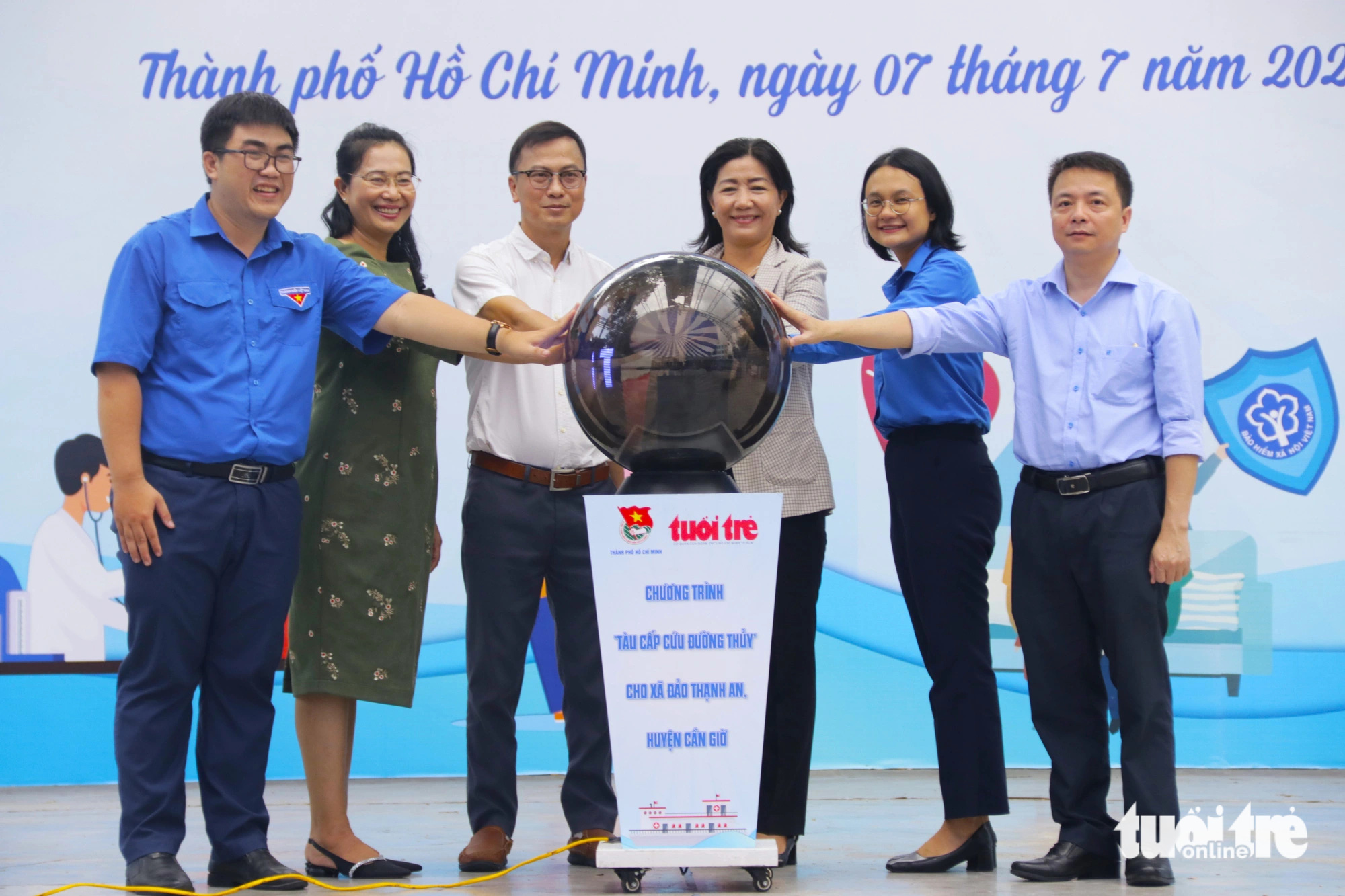 Bà Trần Thu Hà - phó bí thư Thành Đoàn TP.HCM (thứ 2 từ phải qua) và ông Phan Văn Đắc - trưởng ban công tác xã hội báo Tuổi Trẻ (thứ 3 bên trái qua) cùng đại diện lãnh đạo quận 5 thực hiện nghi thức phát động quyên góp ủng hộ chương trình tàu cấp cứu đường thủy cho người dân xã đảo Thạnh An - Ảnh: TIẾN QUỐC