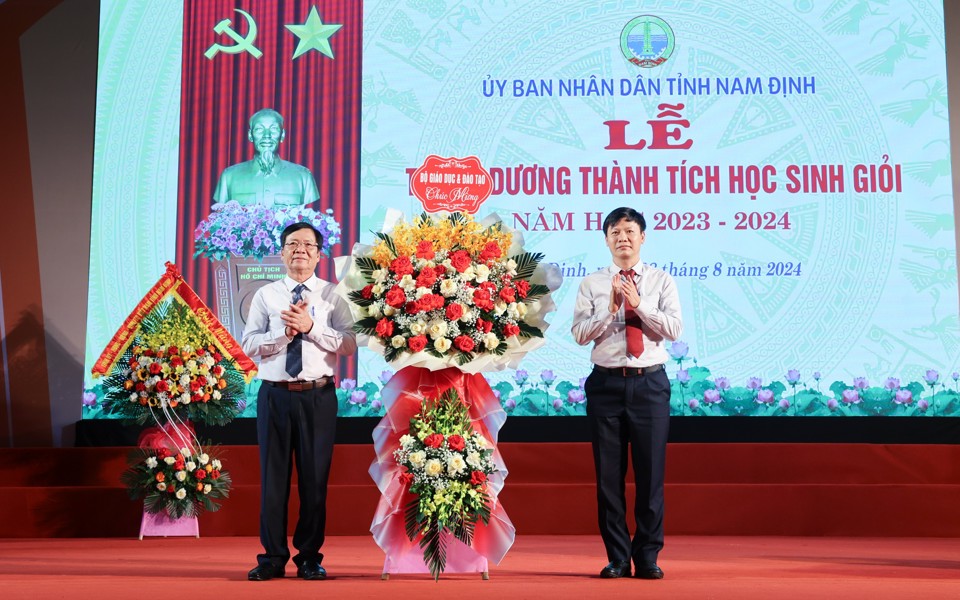 Đại diện Bộ Giáo dục và Đào tạo tặng hoa chúc mừng ngành Giáo dục và Đào tạo Nam Định. Ảnh: Viết Dư