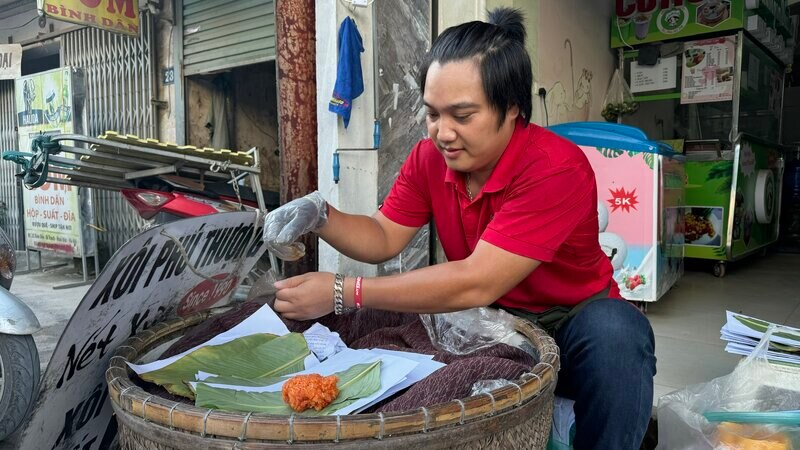 Đôi tay nhanh thoan thoắt gói từng gói xôi giao đến khách hàng. Ảnh: Hoàng Lộc