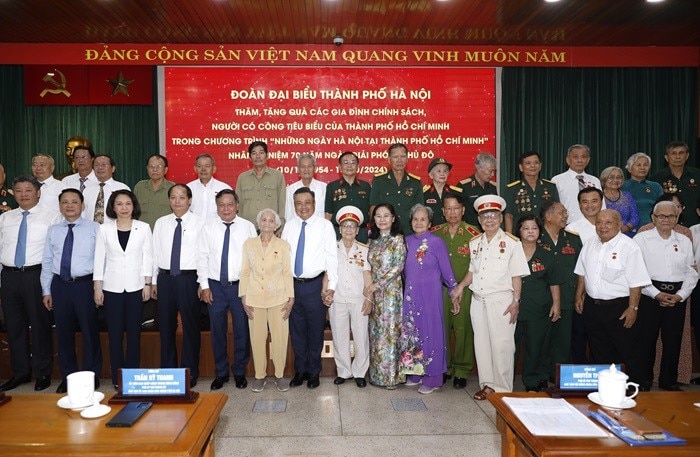 Đại biểu lãnh đạo thành phố Hà Nội và Thành phố Hồ Chí Minh chụp ảnh lưu niệm cùng các gia đình chính sách, người có công (Ảnh: T.L).