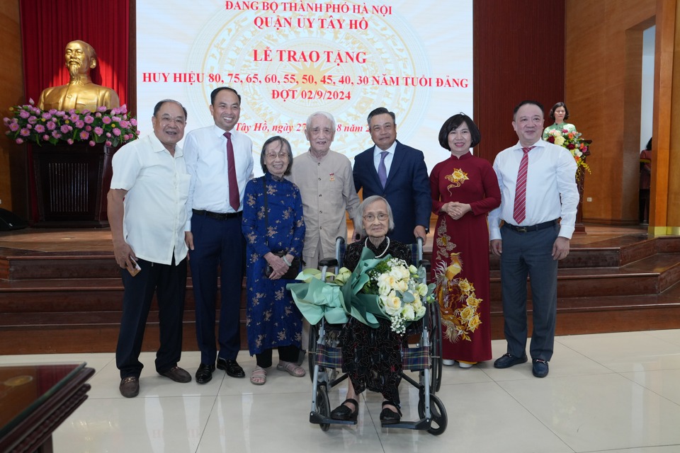 Lãnh đạo TP Hà Nội và quận Tây Hồ chụp ảnh lưu niệm với các đảng viên nhận Huy hiệu 75 năm, 80 năm tuổi Đảng. 