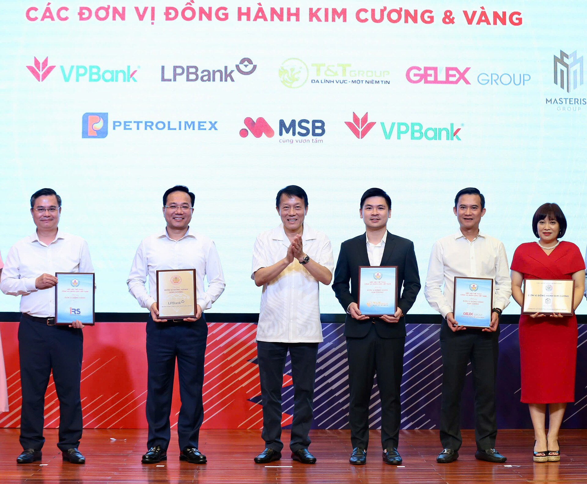 Phó Chủ tịch HĐQT T&T Group Đỗ Vinh Quang (thứ ba từ phải sang) nhận bảng danh vị nhà đồng hành Kim Cương từ Hiệp hội thể thao CAND