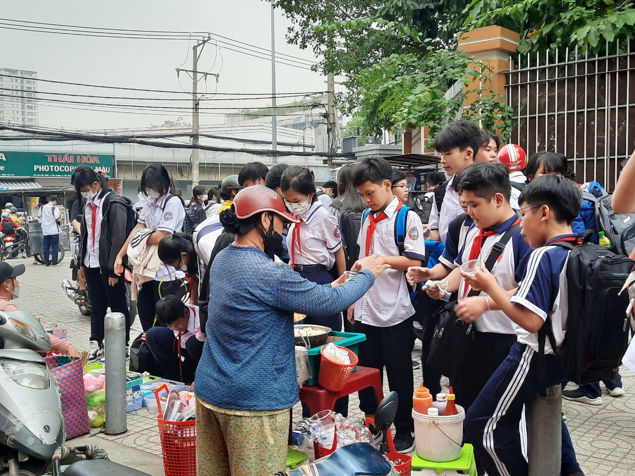 Khi trường học có căng tin sẽ hạn chế được mua bán hàng rong ngoài cổng trường. Trong ảnh: học sinh tại một quận ở TP.HCM ùa ra mua hàng rong sau khi tan học - Ảnh: MỸ DUNG