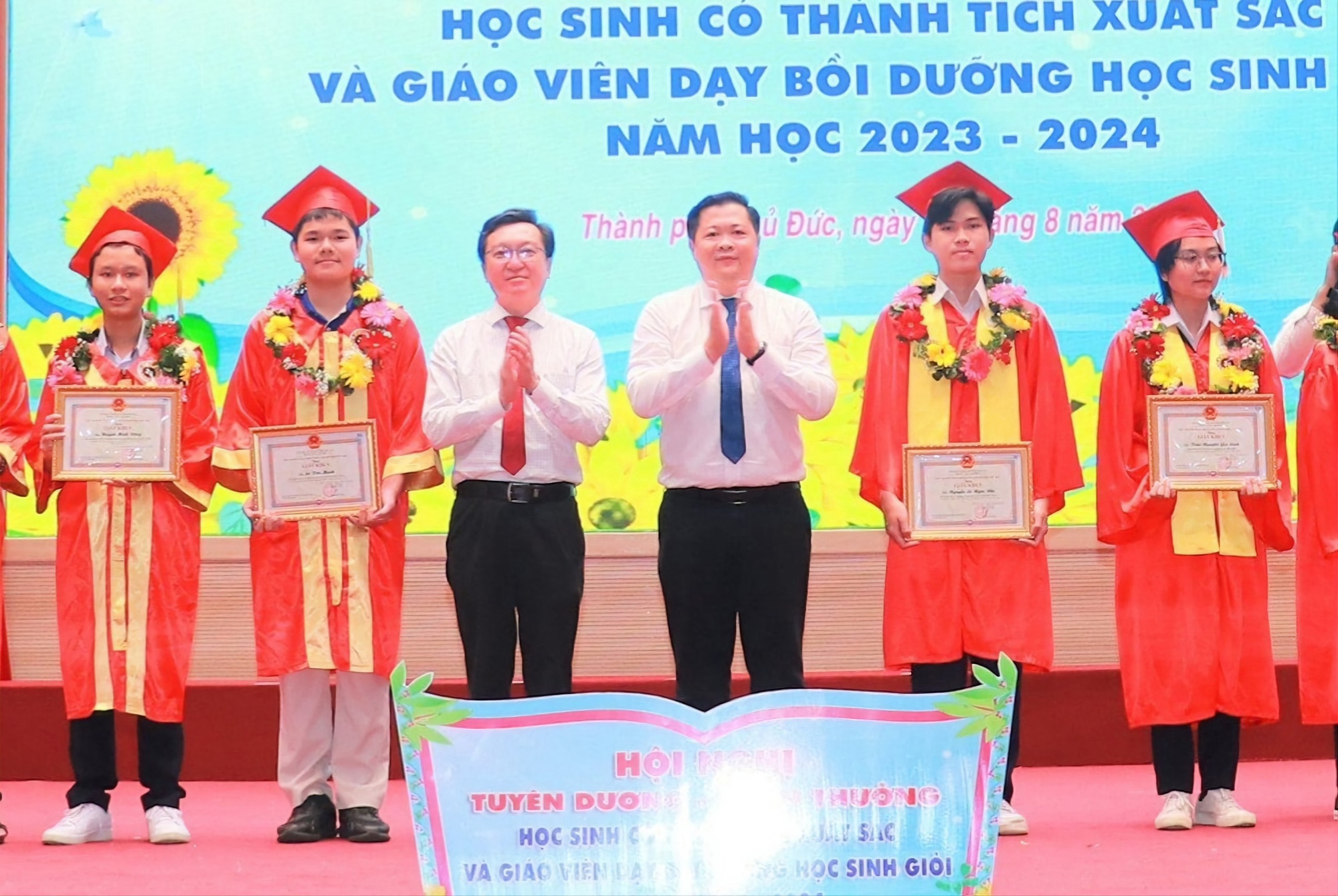 Ông Nguyễn Bảo Quốc, phó giám đốc Sở Giáo dục và đào tạo TP.HCM (thứ ba từ trái sang) và ông Nguyễn Thái Vĩnh Nguyên, trưởng phòng giáo dục và đào tạo TP.Thủ Đức (thứ 4 từ trái sang) trao bằng khen cho các học sinh giỏi - Ảnh: V.N