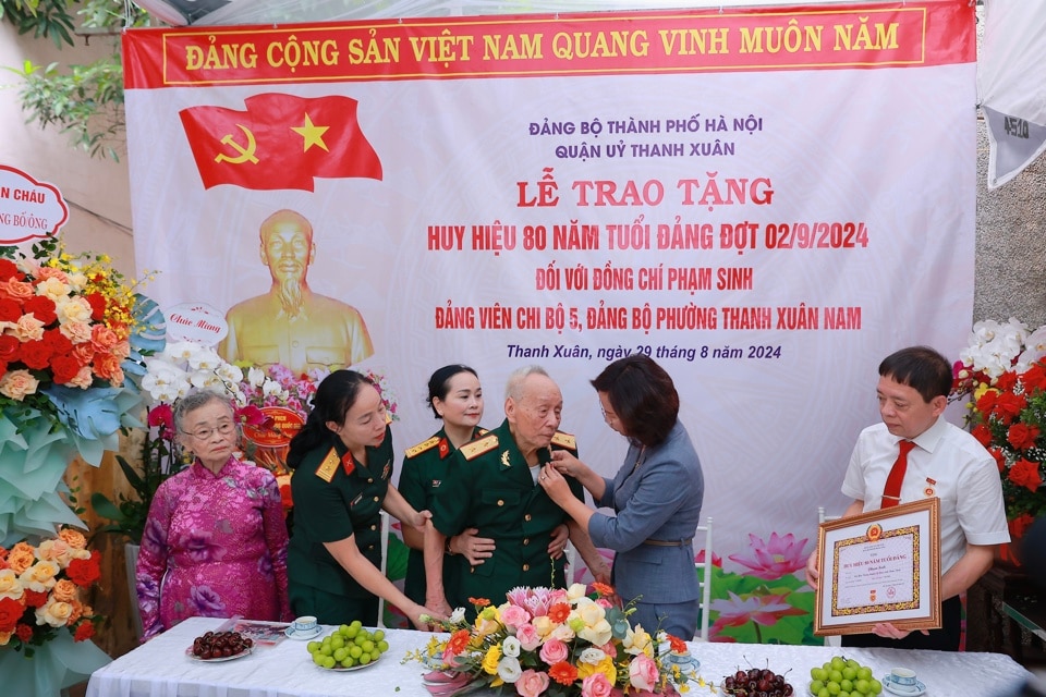 Ủy viên  Ban Thường vụ Thành ủy, Bí thư Quận ủy Thanh Xuân Bùi Huyền Mai gắn Huy hiệu 80 năm tuổi Đảng tặng đảng viên lão thành Phạm Sinh