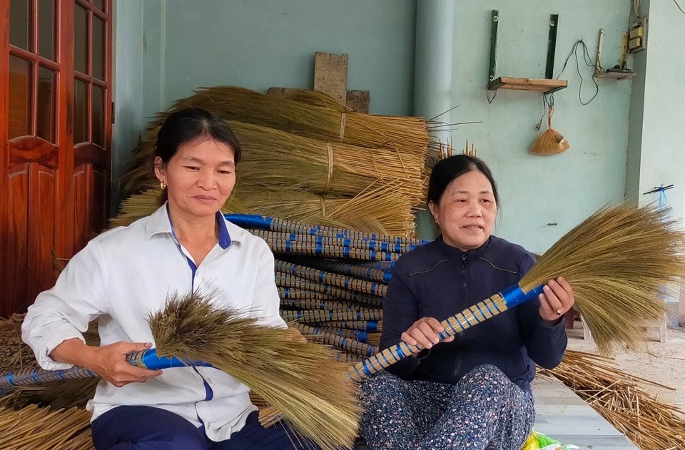 Bà Lê Thị Nhạn (bìa trái) cải thiện được kinh tế gia đình nhờ phần lớn vào nghề làm chổi đót. 