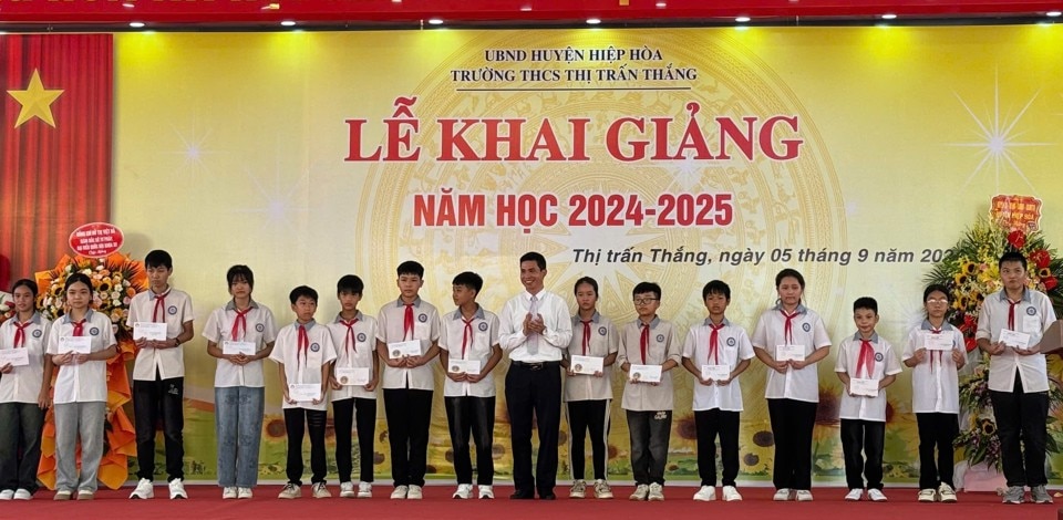 Chủ tịch UBND huyện Hoàng Công Bộ trao quà cho các em học sinh vượt khó vươn lên trong học tập.