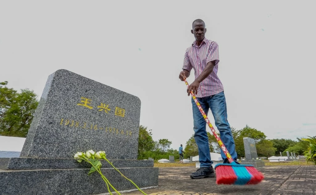 Một công nhân quét sạch nghĩa trang Gongo la Mboto ở Dar es Salaam, Tanzania, vào ngày 12 tháng 8, trong số các bia mộ cho các kỹ sư, kỹ thuật viên và công nhân Trung Quốc đã chết trong khi xây dựng tuyến đường sắt của Cơ quan Đường sắt Tanzania-Zambia (Nguồn: Tân hoa xã)