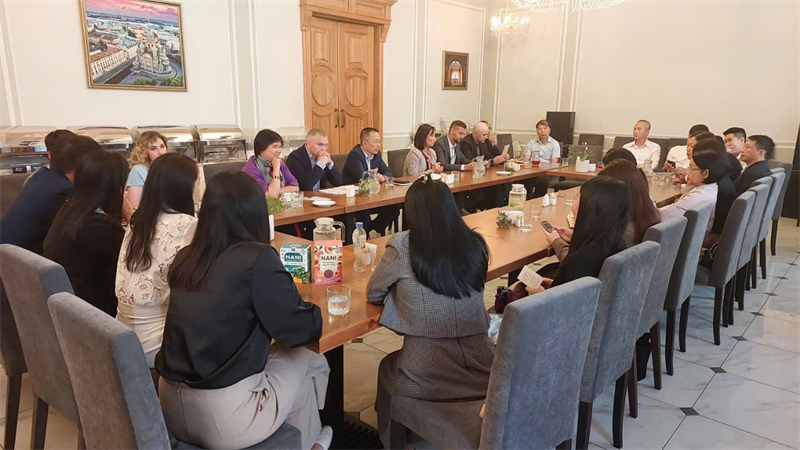 A group of people sitting at a long table  Description automatically generated