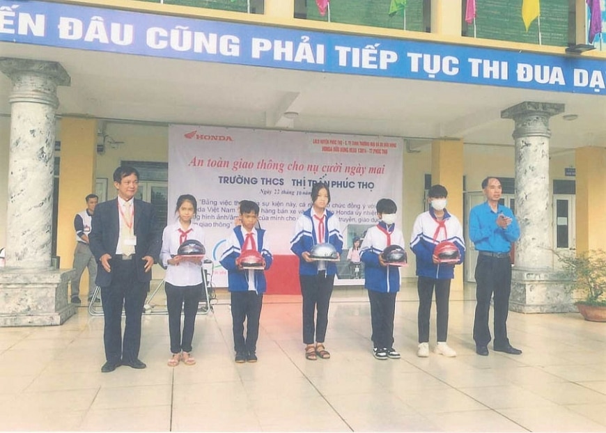 ông Nghiêm Xuân Hữu trao quà cho các học sinh vượt khó học giỏi.