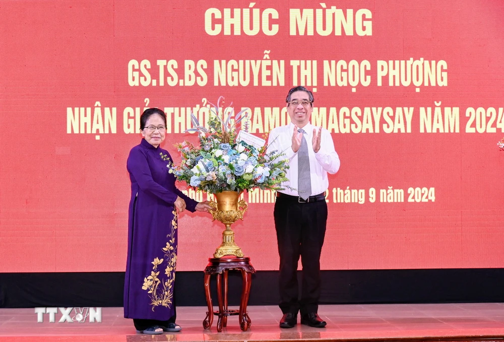 Ông Nguyễn Phước Lộc, Phó Bí thư Thành ủy, Chủ tịch Ủy ban Mặt trận Tổ quốc Việt Nam Thành phố Hồ Chí Minh tặng hoa chúc mừng Giáo sư Nguyễn Thị Ngọc Phượng. (Ảnh: Đinh Hằng/TTXVN)