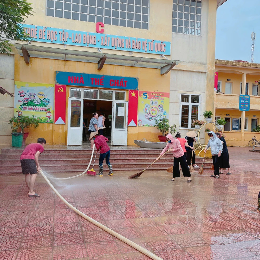 Thầy cô dọn dẹp trường sau bão Yagi. (Ảnh: PV/Vietnam+)