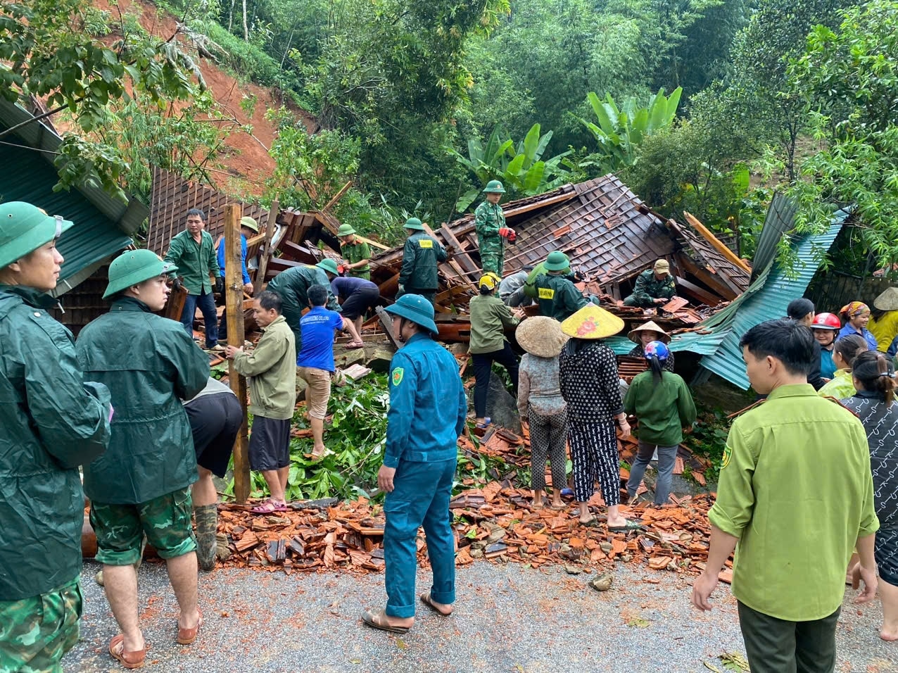 Lực lượng chức năng và người dân chung tay tháo dỡ nhà bà Lương Thị Hoa ở bản Mường Piệt, xã Thông Thụ (Quế Phong) bị đổ sập do sạt lở núi