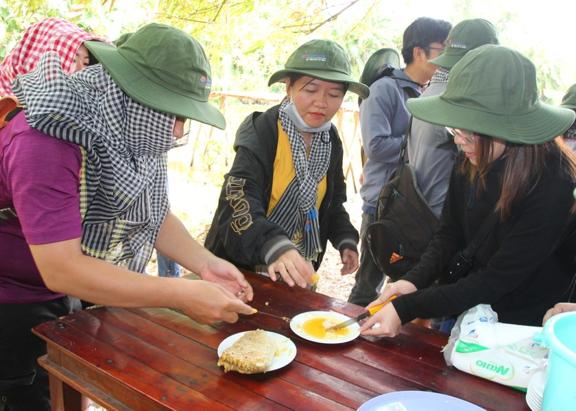 Du khách trải nghiệm vào rừng tràm U Minh Hạ lấy ong và thưởng thức vị mật ong thơm ngon.