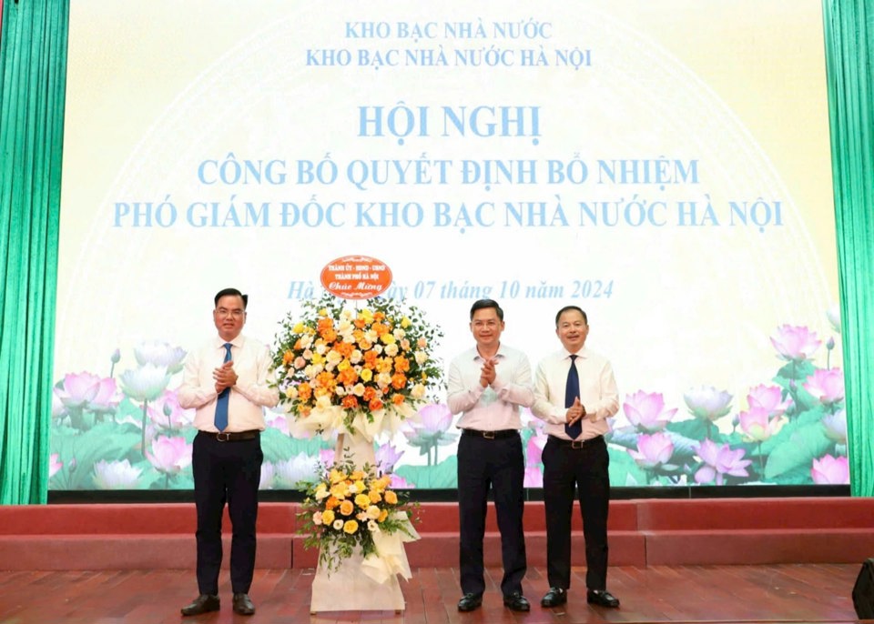 Phó Chủ tịch UBND TP Hà Nội Hà Minh Hải tặng hoa hai tân Phó Giám đốc Kho bạc Nhà nước Hà Nội. Ảnh: T.G