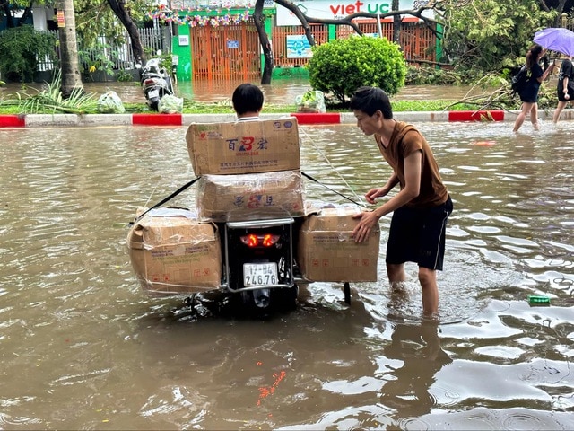 Nhân viên cửa hàng đi giao hàng trong ngày lụt