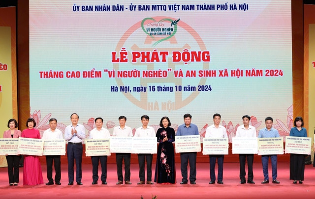 Phó Bí thư Thường trực Thành ủy Nguyễn Thị Tuyến và Chủ tịch HĐND TP Nguyễn Ngọc Tuấn trao biểu trưng cho đại diện các đơn vị được nhận hỗ trợ khắc phục hậu quả bão, lũ trên địa bàn TP Hà Nội