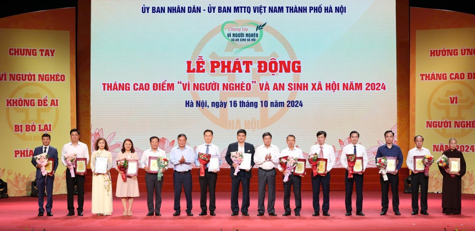 Phó Bí thư Thành ủy Hà Nội Nguyễn Văn Phong và Phó Chủ tịch UBND TP Hà Nội Dương Đức Tuấn trao biểu trưng cho các tập thể, cá nhân tiêu biểu có đóng góp tích cực cho công tác giảm nghèo và an sinh xã hội của TP Hà Nội