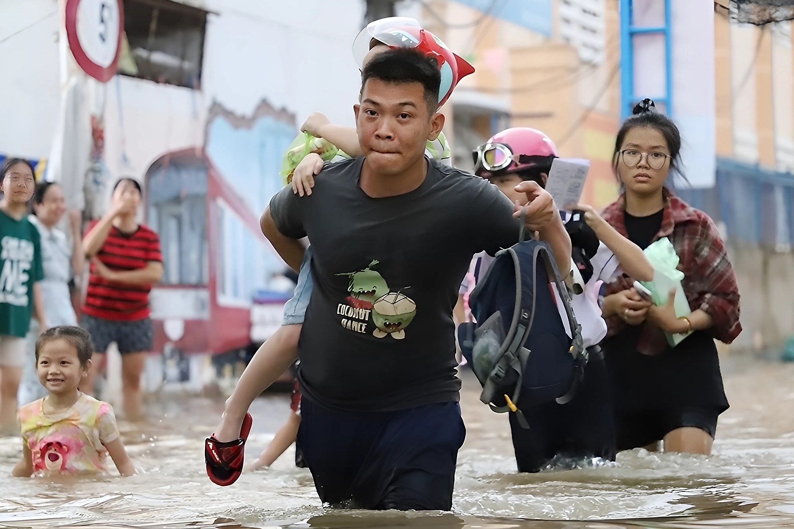 Triều cường vượt mức báo động 3, người dân vượt 'biển nước' đưa con về nhà