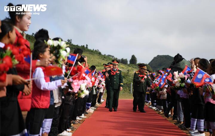 Học sinh Trường Tiểu học-Trung học cơ sở Pahang vẫy cờ, hoa chào đón hai Bộ trưởng. (Ảnh: Trịnh Sơn)