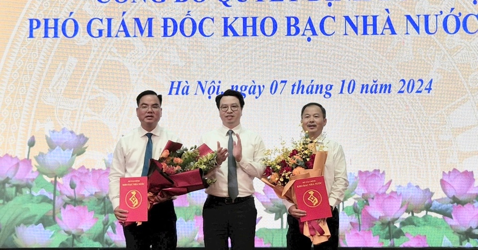 Tổng Giám đốc Kho bạc Nhà nước Trần Quân trao quyết định bổ nhiệm cho ông Nguyễn Văn Tường (bên phải người trao) và ông Nguyễn Mạnh Đức. Ảnh: Hương Thủy