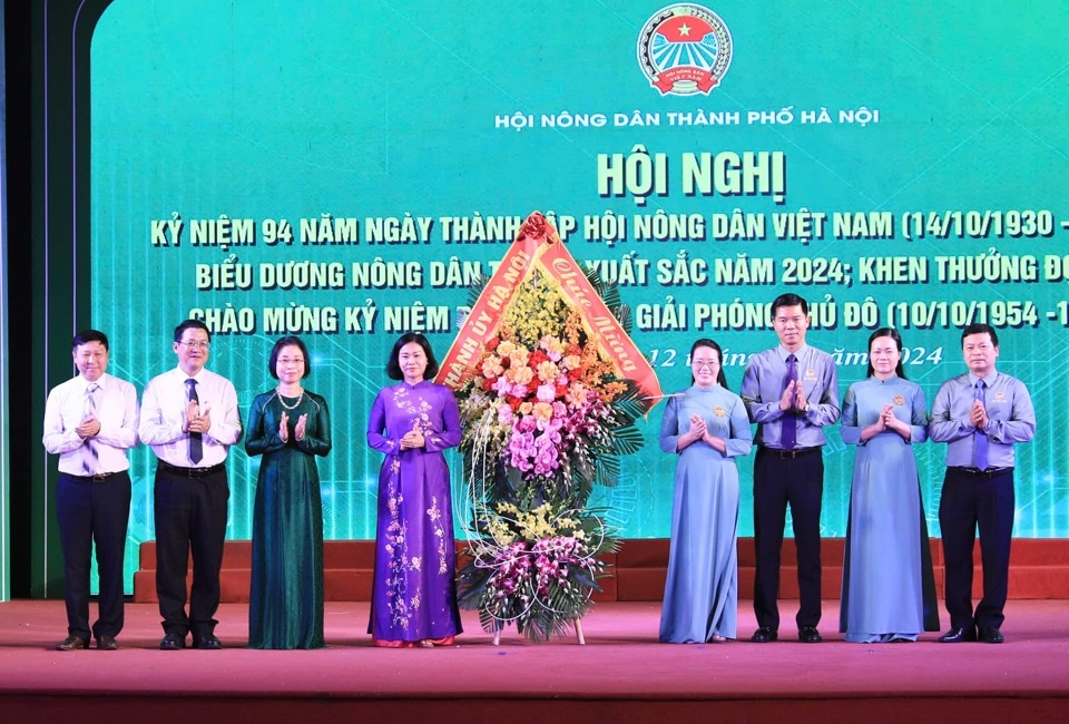 Phó Bí thư Thường trực Thành ủy Hà Nội Nguyễn Thị Tuyến và đại biểu TP Hà Nội tặng hoa chúc mừng Hội Nông dân TP.  Ảnh: Phạm Hùng