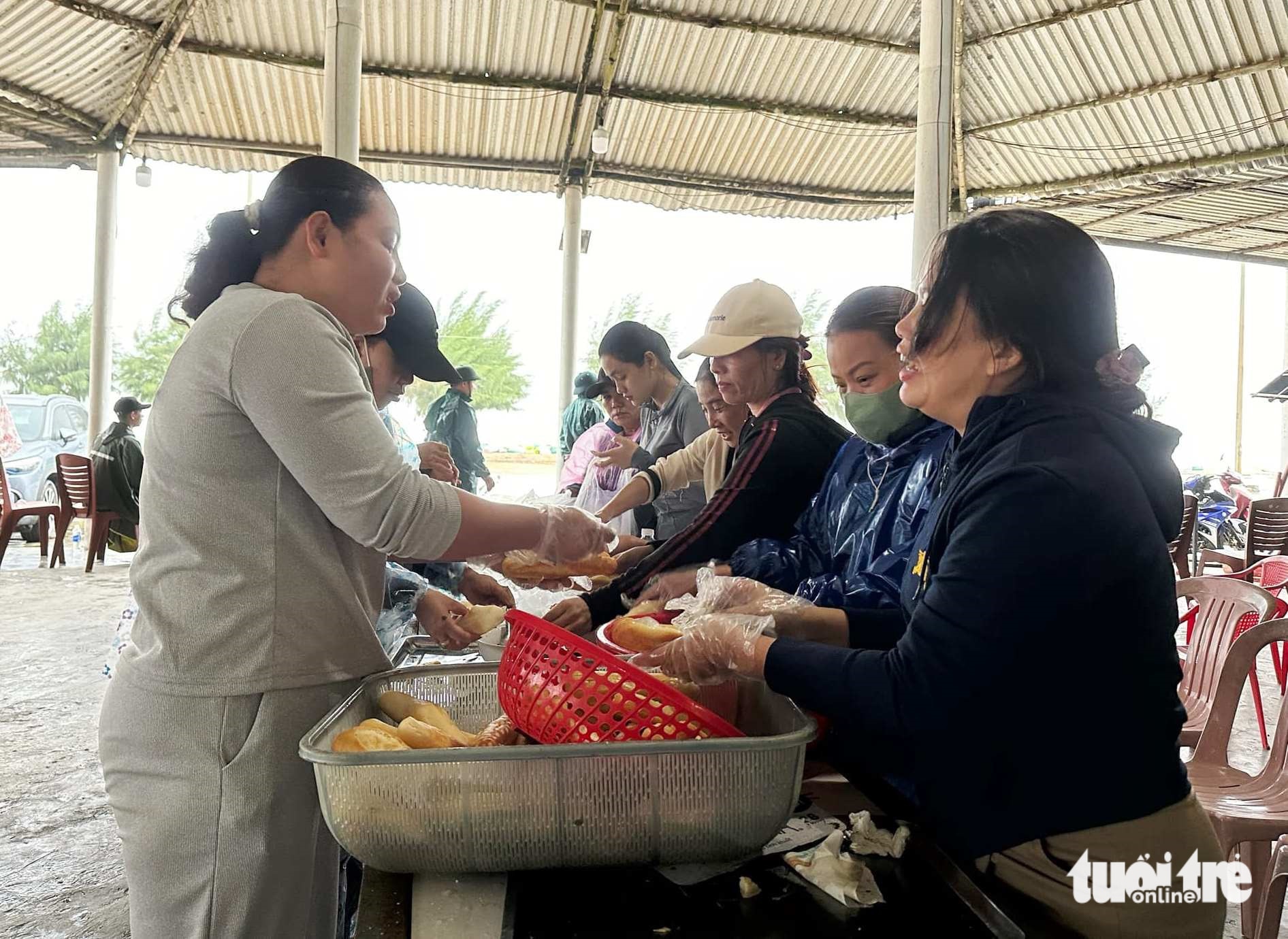 Góp tiền mua mì, nước, bánh lọc tặng bộ đội đắp đê chắn sóng giúp dân trước bão Trà Mi - Ảnh 1.