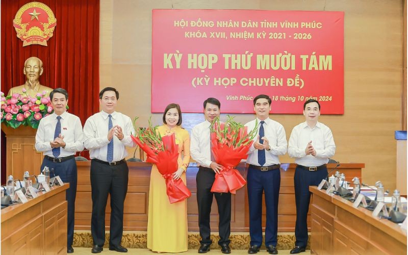 Ông Nguyễn Khắc Hiếu và bà Phùng Thị Kim Nga nhận hoa chúc mừng của các đại biểu