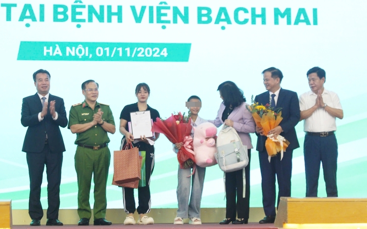 Lãnh đạo Bộ Y tế, Bệnh viện Bạch Mai và các ban ngành tặng hoa chúc mừng bệnh nhi trong ngày xuất viện. (Ảnh: N.Loan)