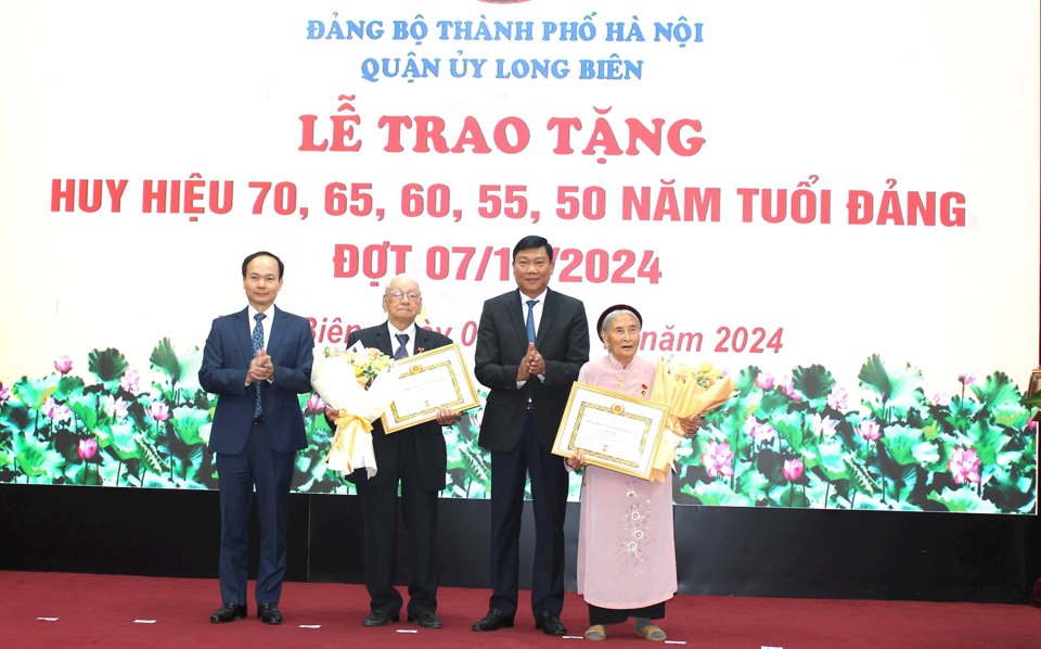 Trưởng ban Dân vận Thành ủy Đỗ Anh Tuấn và lãnh đạo quận Long Biên trao Huy hiệu Đảng tặng các đảng viên lão thành. 