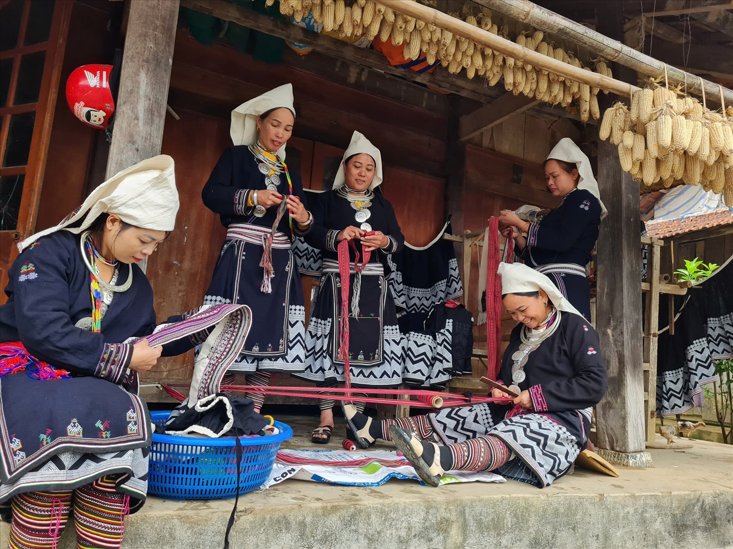 Chị em dân tộc Dao ở Tân Cường (xã Tân An, huyện Chiêm Hóa) tỉ mỉ se từng sợi chỉ để thêu, chấm sáp ong trên vải 