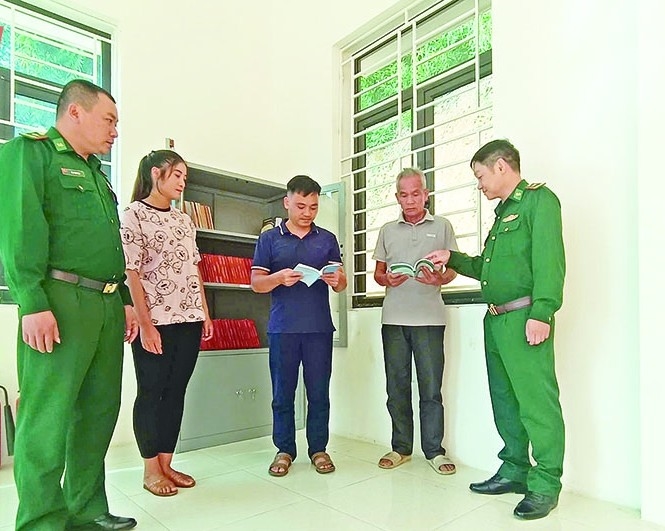 Cán bộ Đồn Biên phòng Hiền Kiệt, Ban Quản lý bản Chiềng Căm, xã Hiền Kiệt đẩy mạnh tuyên truyền cho bà con thông qua tủ sách pháp luật.