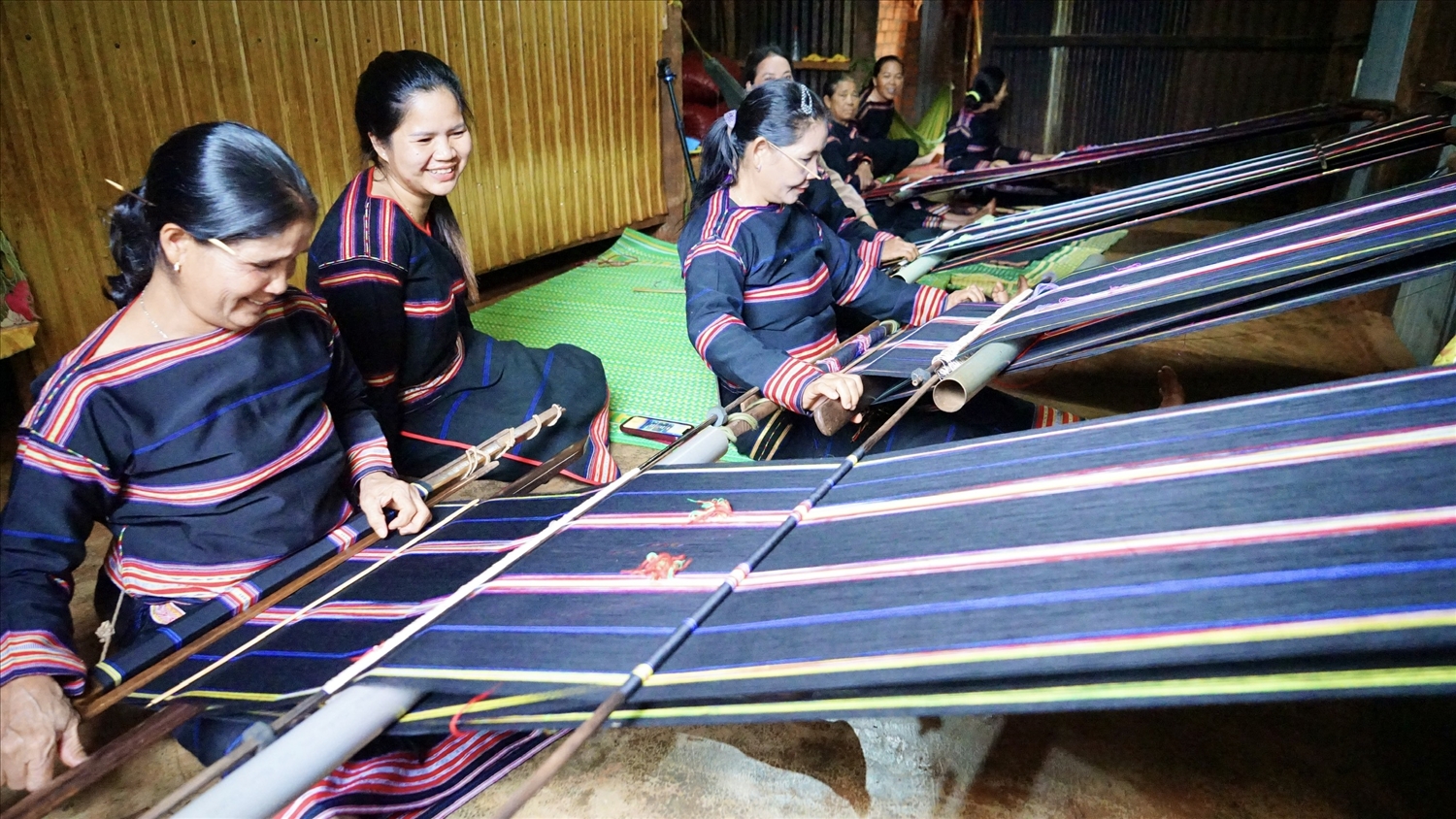 Các thành viên mô hình "Đan, dệt thổ cẩm" tại làng Thơh Ga B, xã Chư Don, huyện Chư Pưh say mê bên khung cửi dệt vải