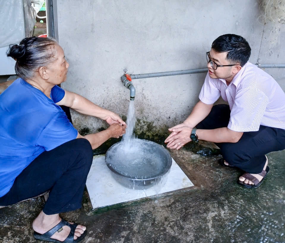 Bà Nguyễn Thị Thảo, thôn Chản, xã Nhân Lý bên nguồn nước sinh hoạt thực hiện từ vốn vay chương trình nước sạch và vệ sinh môi trường nông thôn. 