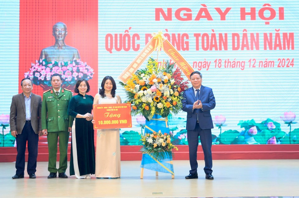 Phó Bí thư Thường trực Thành ủy Hà Nội Nguyễn Văn Phong tặng hoa chúc mừng phường Vĩnh Phúc. 