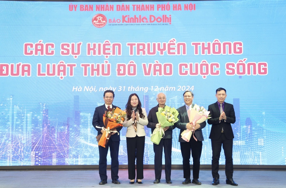 Tổng Biên tập Báo Kinh tế & Đô thị Nguyễn Thành Lợi và Phó Giám đốc Sở Tư pháp Hà Nội Phạm Thị Thanh Hương tặng hoa các diễn giả