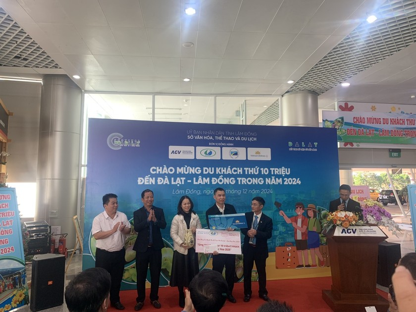 Đại diện Vietnam Airline tặng quà vị khách đặc biệt đến Lâm Đồng trên chuyến bay của hãng.