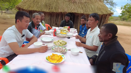 Pessoas africanas comem bolos do Ano Novo vietnamita.png