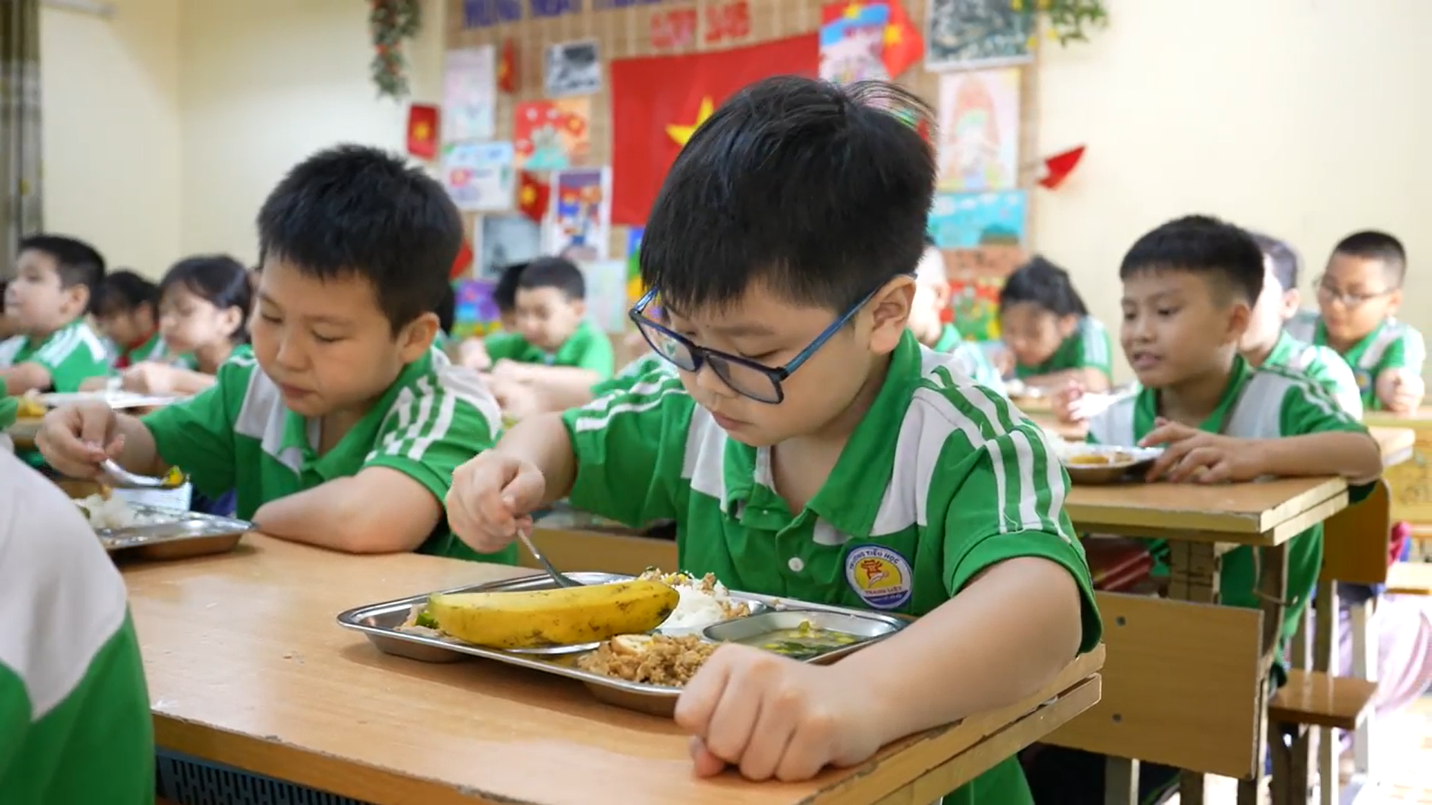 A group of children eating in a classroom  Description automatically generated