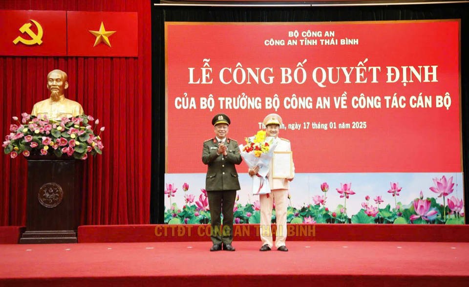 Đại tá Trần Xuân Ánh - Giám đốc Công an tỉnh Thái Bình trao quyết định, tặng hoa chúc mừng Thượng tá Phạm Thanh Tiến. Ảnh: CACC