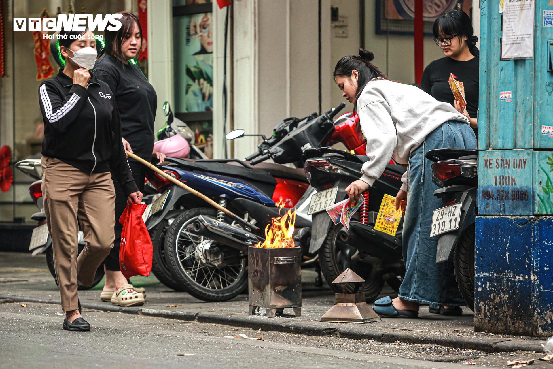 ハノイの人々は旧市街の歩道で道権を崇拝するために奉納紙を燃やす - 15