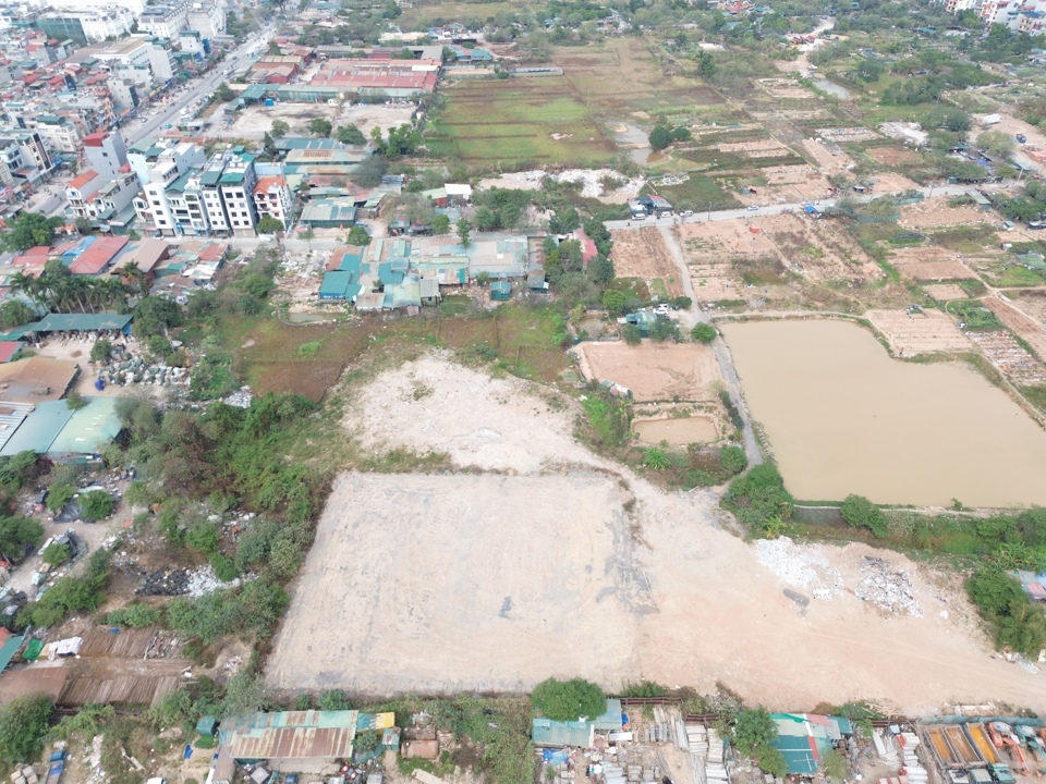 Ngay sát bãi tập kết, máy móc, thiết bị và vật liệu xây dựng là một bãi đất rộng đã bị san lấp mặt bằng, lu lèn bằng phẳng. Ảnh: Nguyễn Quý