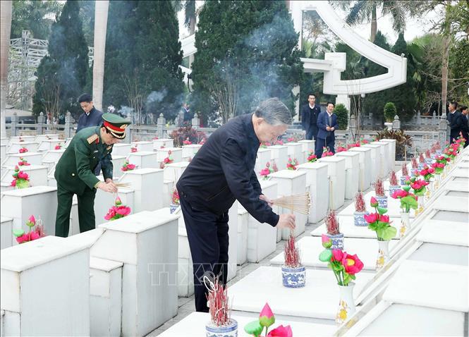 Tổng Bí thư Tô Lâm thắp hương trên phần mộ các liệt sĩ tại Nghĩa trang liệt sĩ Quốc gia Vị Xuyên. Ảnh: Thống Nhất/TTXVN