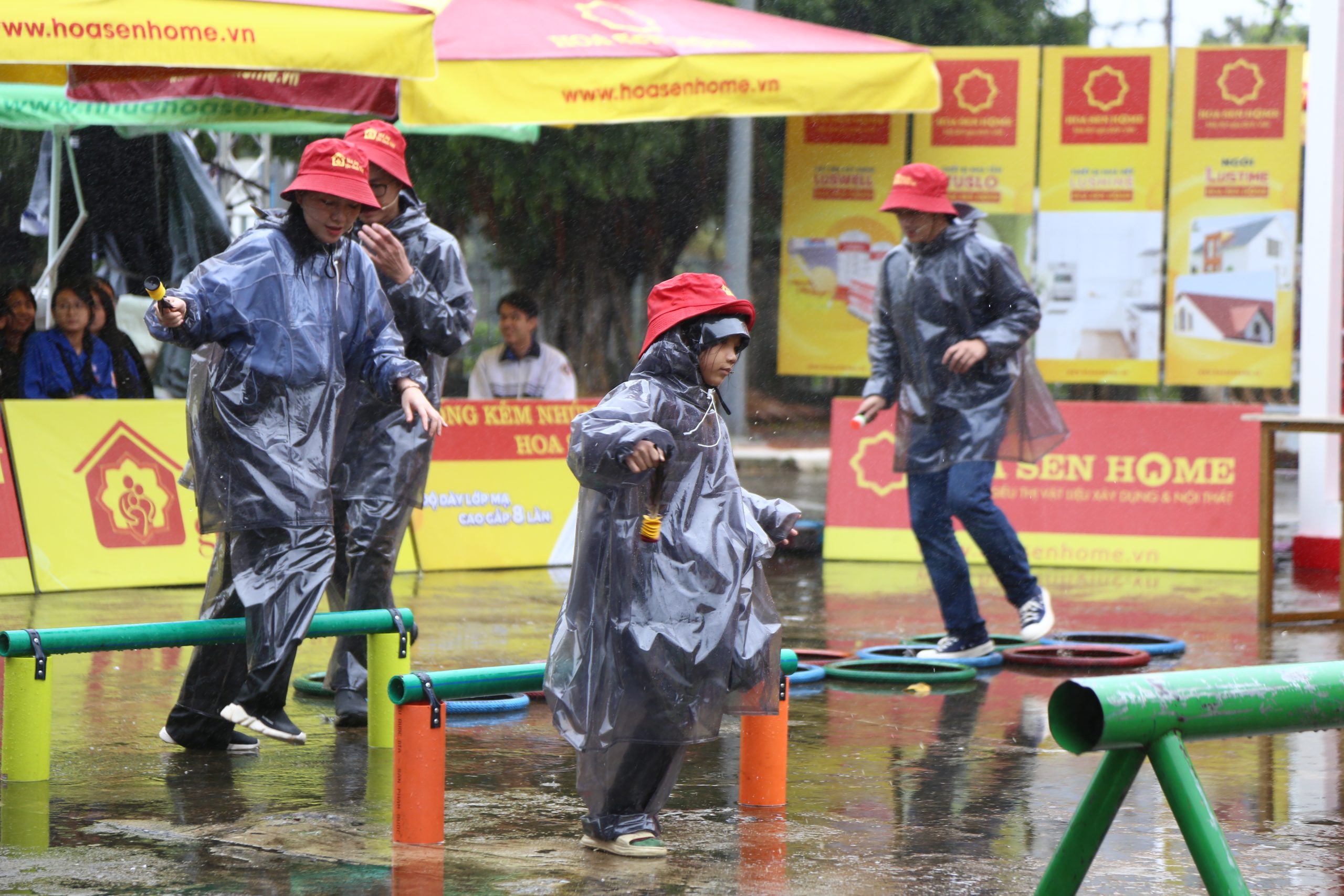 MC Anh Quân, diễn viên Băng Di và diễn viên Samuel An bất chấp mưa gió để thực hiện thử thách. 